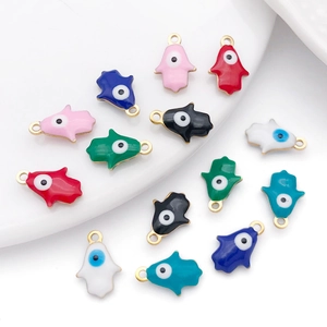Macro detail of Hamsa Hand and Evil Eye charms in colorful enamel for DIY jewelry making
