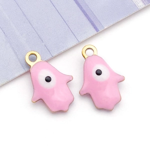 Macro shot of pink enamel evil eye palm charms with gold metal edges for DIY jewelry making