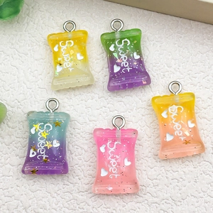 Macro shot of colorful resin candy charms with Sweet lettering and glitter for DIY jewelry