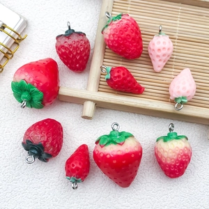 Macro shot of resin strawberry charms in various red and pink shades for DIY jewelry making