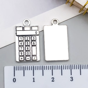 Detail view of mini calculator charm with ruler for DIY jewelry and keychain projects