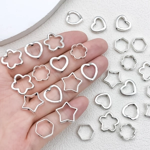 DIY Silberlegierung Herz- und Sternanhänger auf der Hand zur Größenreferenz präsentiert