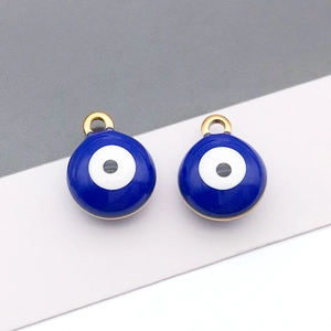 Dettaglio di ciondoli malocchio in smalto blu da 8mm con anelli dorati per collane DIY