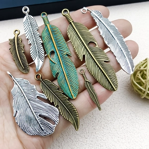 Assorted vintage alloy feather pendants for DIY jewelry making in multiple metal finishes