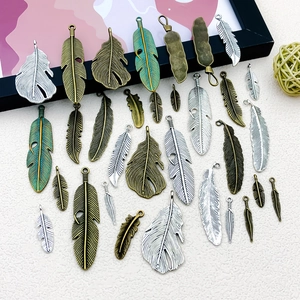 Assorted vintage alloy feather pendants for DIY jewelry making in multiple metallic finishes