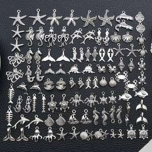 Macro view of assorted antique silver ocean charms like starfish and seahorse for DIY