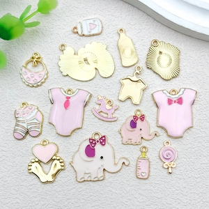 Detalle de dijes esmaltados en rosa y blanco para creación de joyería artesanal