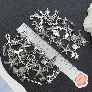 Antique silver marine alloy charms set with starfish and seahorse on black background