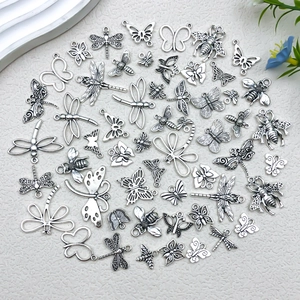 Detailed overhead view of vintage silver insect pendants for DIY jewelry making