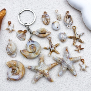 Detailed flat lay of beige resin starfish and seashell pendants for DIY jewelry crafts