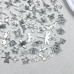Macro shot of vintage silver insect charms including butterflies and bees for DIY jewelry