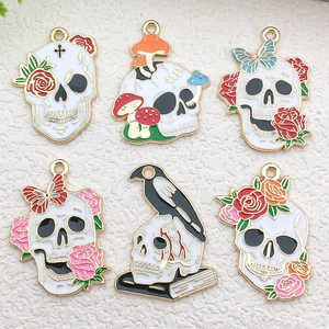 Detail view of six unique enamel skull pendants with roses, mushrooms, and ravens for DIY jewelry