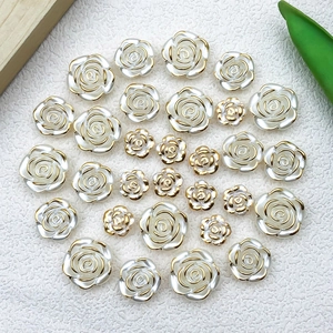 Detail of white resin rose charms with gold edges and vintage camellia floral design