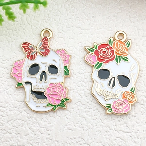 Detailed close-up of gothic skull enamel charms with floral accents for DIY jewelry making