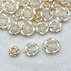 Detail of white pearl acrylic rose beads with gold edges in three varying sizes