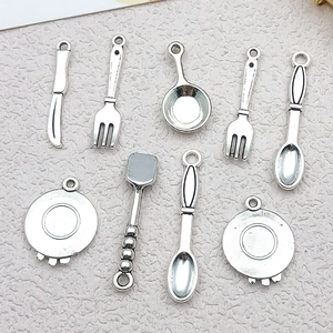 Macro detail of nine antique silver alloy kitchenware charms for DIY jewelry making