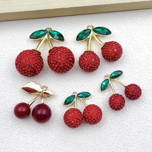 Detailansicht der roten Strass-Kirsch-Anhänger mit grünen Blättern für DIY-Schmuck
