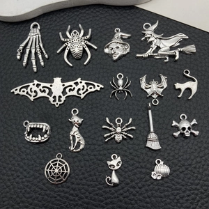 Detailed flat lay of 15 vintage silver Halloween alloy charms on black leather background