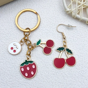 Detail of fruit charms keychain with cherry and strawberry pendants in gold finish