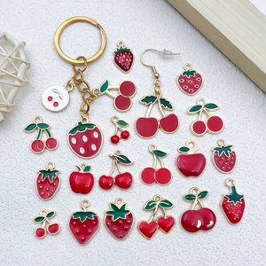 Detail of colorful fruit pendants with red enamel strawberry, cherry, and apple charms
