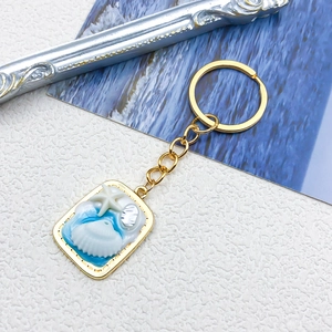 Dettaglio portachiavi dorato a tema oceanico con stella marina e onde in resina blu