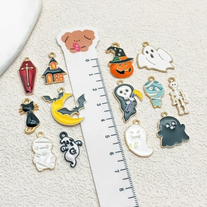 Flat lay of colorful enamel Halloween charms including ghost, pumpkin and bat designs