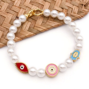 Detail view of pearl bracelet featuring colorful enamel Hamsa Hand and Evil Eye charms