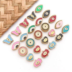 Flat lay of colorful enamel Hamsa Hand and Evil Eye beads for DIY jewelry making