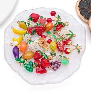 Pendentifs en émail aux fruits variés pour bijoux DIY sur un plateau en verre dépoli