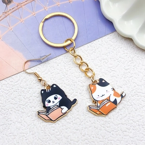 Detail van DIY emaille katten sleutelhanger en oorbellen set met lezende katjes