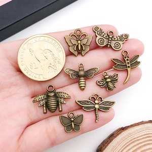 Vue détaillée de breloques insectes en bronze à côté d'une pièce pour la taille