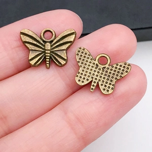 Détail d'un pendentif papillon en bronze vintage pour bijoux DIY montrant les deux côtés