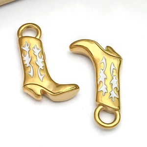 Gros plan de pendentifs bottes de cow-boy en émail doré pour création de bijoux DIY