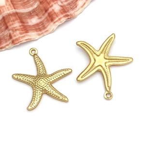 Macro shot of gold stainless steel starfish pendants showing textured surface details