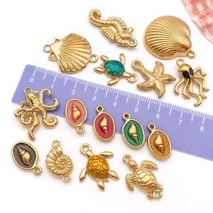 Pendentifs marins dorés incluant hippocampe et tortue avec règle pour les dimensions