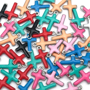 Macro view of colorful enamel cross charms in various colors for DIY jewelry making