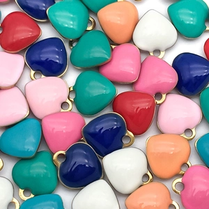 Macro shot of colorful enamel heart charms with gold edges for DIY jewelry making