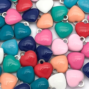 Macro shot of colorful enamel heart charms in multiple vibrant shades with silver rings