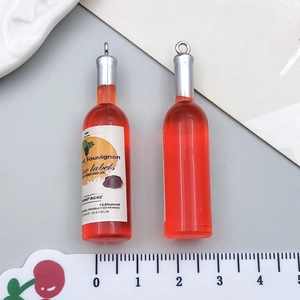 Vista dettagliata di due ciondoli a forma di bottiglia di vino in resina da 3,5 cm