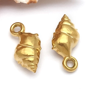 Macro-opname van matte gouden schelphangers met oogjes voor DIY-sieraden maken