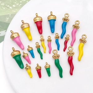 Détails macro de pendentifs piment en émail coloré avec capuchons dorés texturés