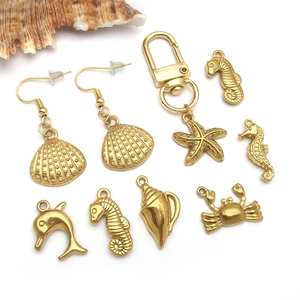 Goldene Schmuckanhänger aus Edelstahl mit Meeresmotiven wie Seestern und Muscheln