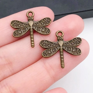 Detalle macro de colgantes de libélula en bronce con alas en relieve para bisutería
