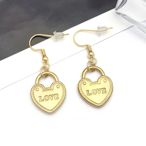 Gros plan de boucles d'oreilles cadenas cœur doré avec gravure LOVE et attaches crochet