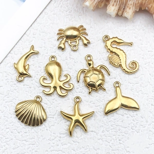 Flat lay of gold stainless steel ocean-themed charms for DIY necklace jewelry making