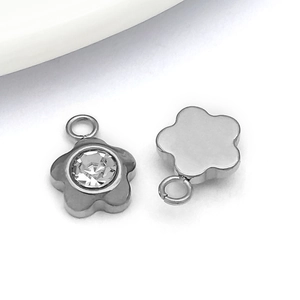 Vista macro de colgantes florales plateados con circonita para joyería artesanal DIY