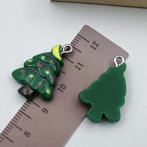 Dettaglio di ciondoli a forma di albero di Natale in resina verde con perline colorate