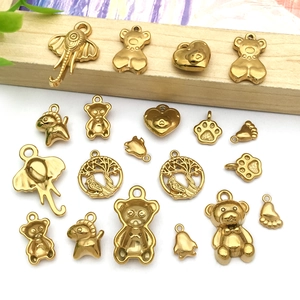 Detailed macro of gold plated stainless steel charms including elephant and bear shapes