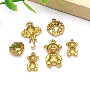 Detailed close-up of golden stainless steel pendants with elephant and bear motifs