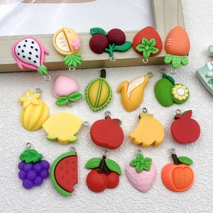 Dettaglio di vari ciondoli a forma di frutta in resina con ganci per gioielli fai-da-te